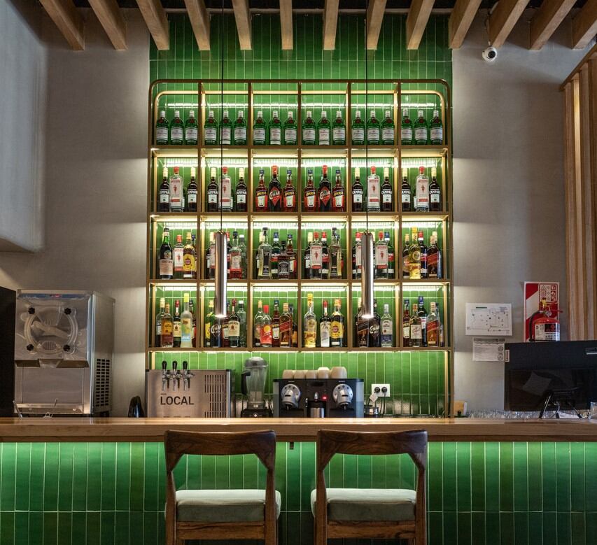 La barra de Mess en tonos verdes, que combina muy bien con los tonos madera del ambiete