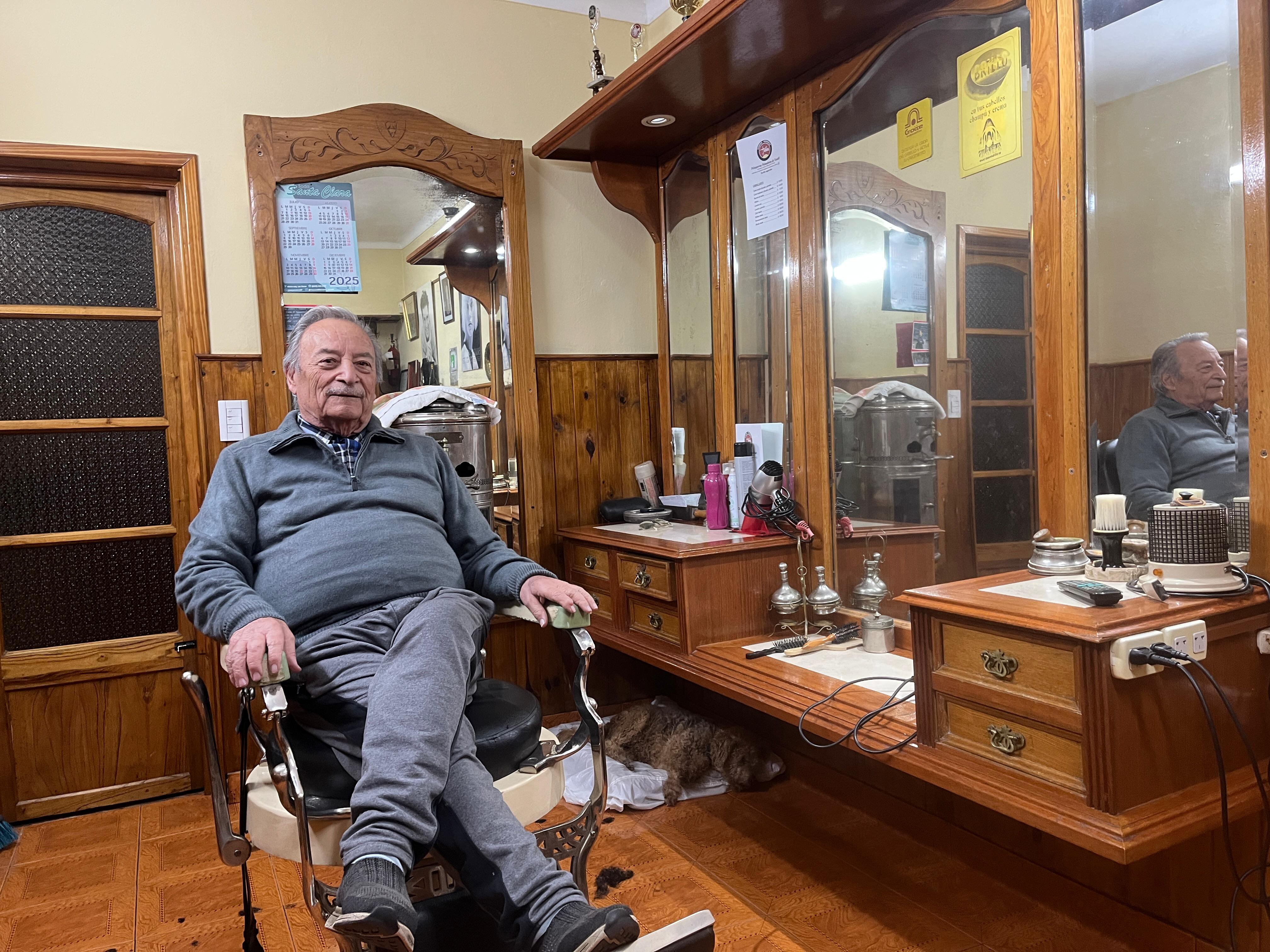 El sillón de barbero y el mostrador con el espejo son dos de los muebles que acompañan a Vicente desde que empezó con la peluquería en Argentina en 1951