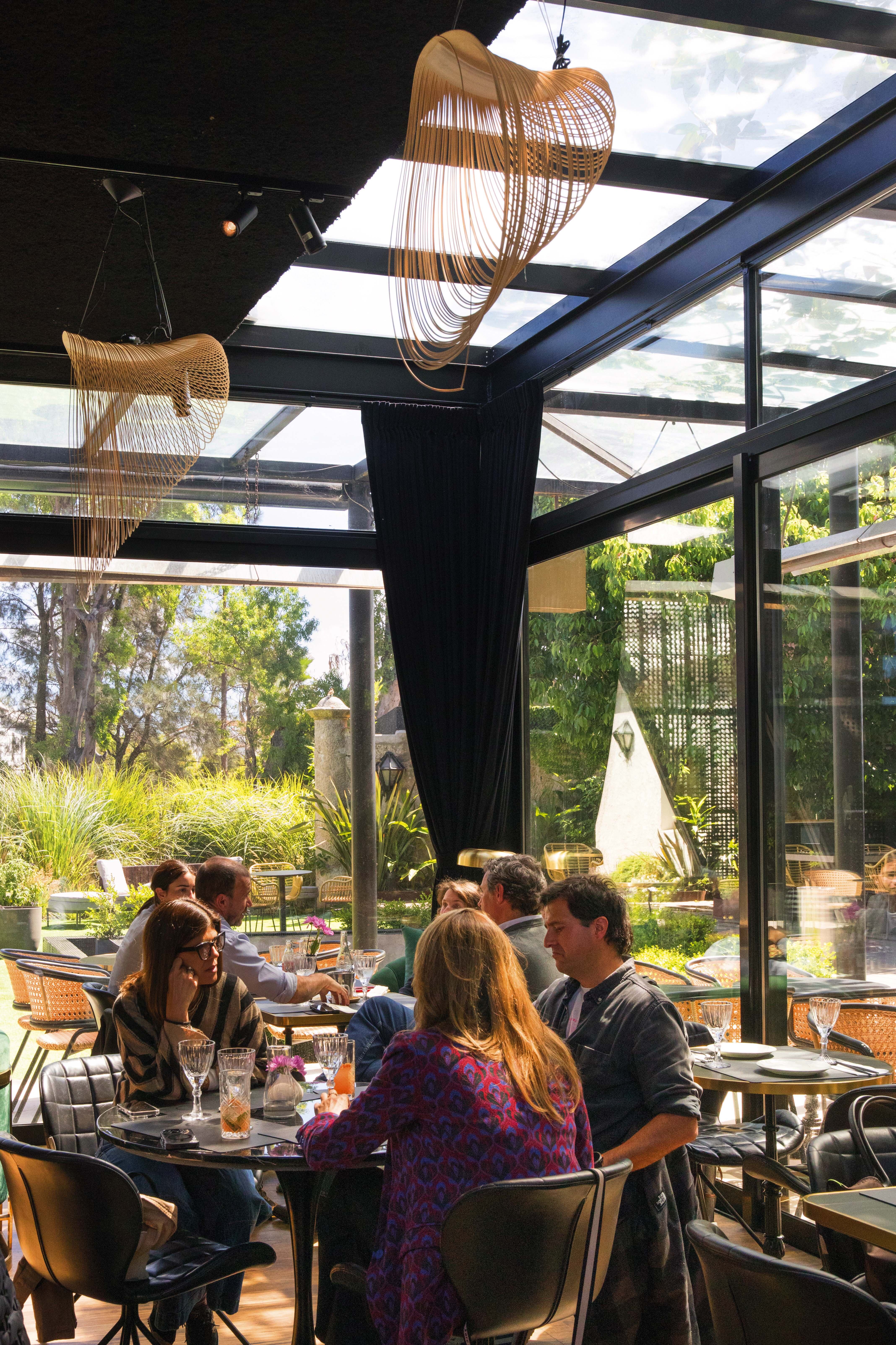 El salón tiene grandes ventanales a los jardines de Carrasco