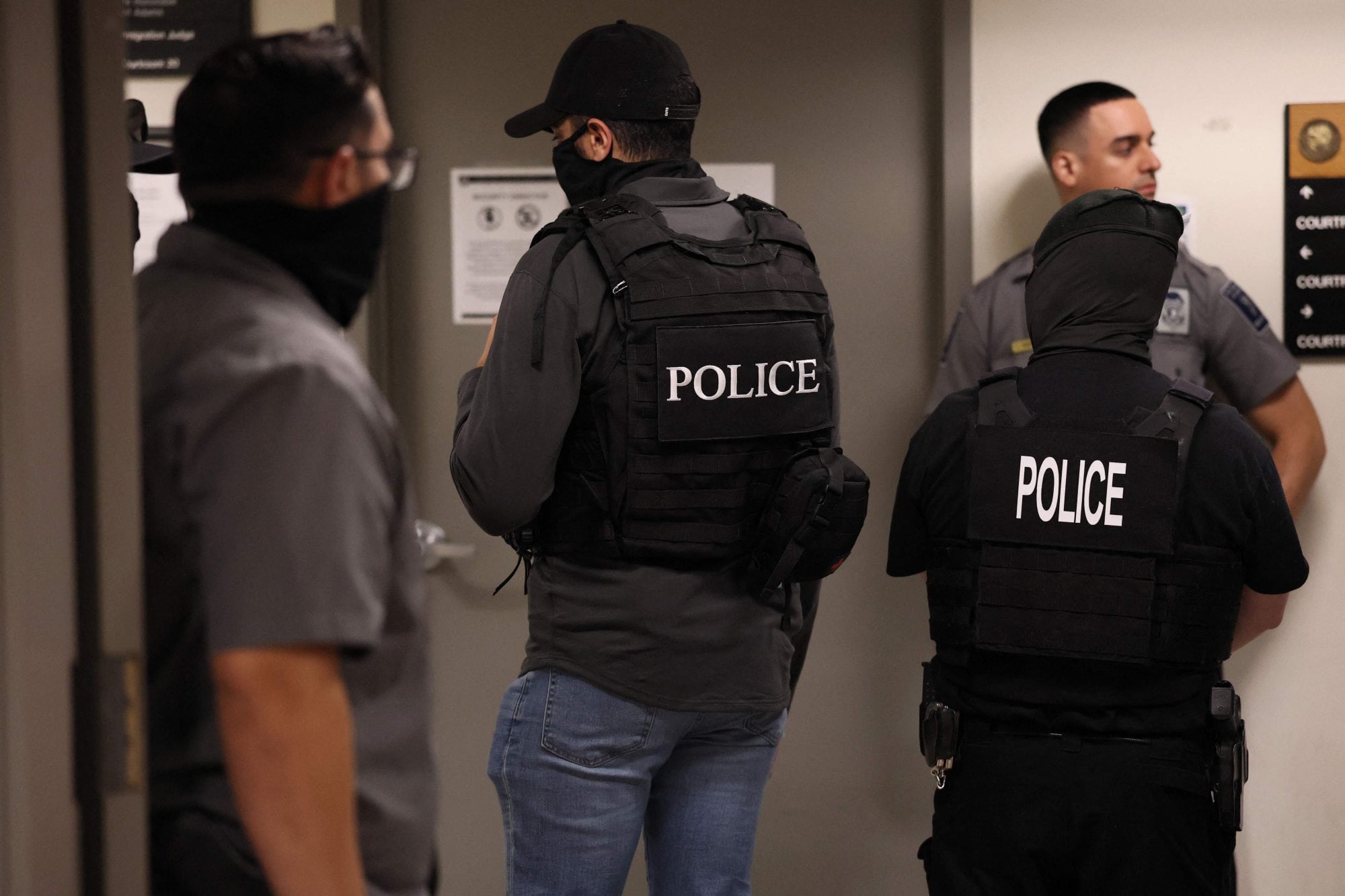 Agentes del ICE, en los pasillos de la corte, esperan a los migrantes para detenerlos