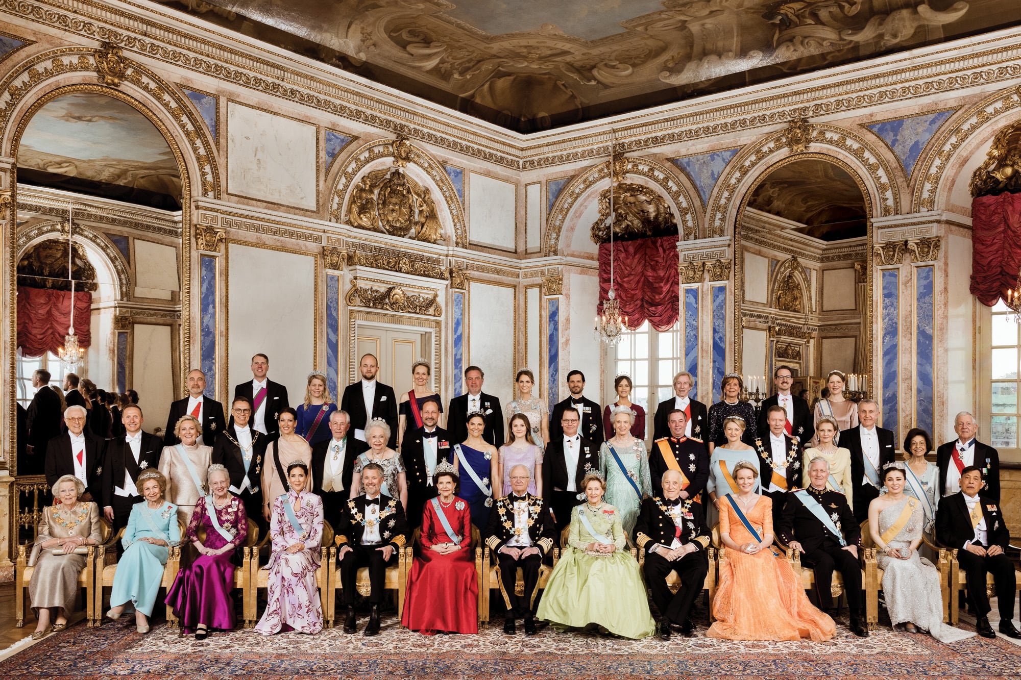 De izquierda a derecha, sentados: la princesa Beatriz de Holanda, la reina Sofía de España, la reina Margarita II de Dinamarca, la reina Mary y el rey Federico X de Dinamarca, la reina Silvia y el rey Carlos XVI Gustavo de Suecia, la reina Sonia y el rey Harald V de Noruega, la reina Matilde y el rey Felipe de Bélgica, la reina Suthida y el rey Rama X de Tailandia. De izquierda a derecha, parados: el duque Francisco de Baviera, el primer caballero Björn Skúlason de Islandia, la presidenta Halla Tómasdóttir de Islandia, el presidente Alexander Stubb de Finlandia y la primera dama Suzanne Innes-Stubb, Tord Gösta Magnuson y la princesa Cristina de Suecia, el príncipe heredero Haakon Magnus, la princesa Victoria de Suecia, la princesa Estelle de Suecia, Daniel de Suecia, la princesa Benedicta de Dinamarca, Guillermo V y Stephanie de Luxemburgo, El gran duque Enrique de Luxemburgo, la princesa Margarita y el príncipe Radu de Rumania, la princesa Katherine Batis y el príncipe Alejandro de Yugoslavia. De izquierda a derecha, detrás: Thomas Greinwald, marido del duque Francisco de Baviera, príncipe Hubertus de Sajonia-Coburgo y Gotha y la princesa Kelly de Sajonia-Coburgo-Gotha, Josef Wenzel y Sophie de Liechtenstein, Chris O’Neill y Magdalena de Suecia, Carlos Felipe y la princesa Sofía de Suecia, el príncipe Leopoldo de Baviera, la princesa Ursula von Bayern, el príncipe Felipe Karadjordjevic y la princesa Danica de Serbia