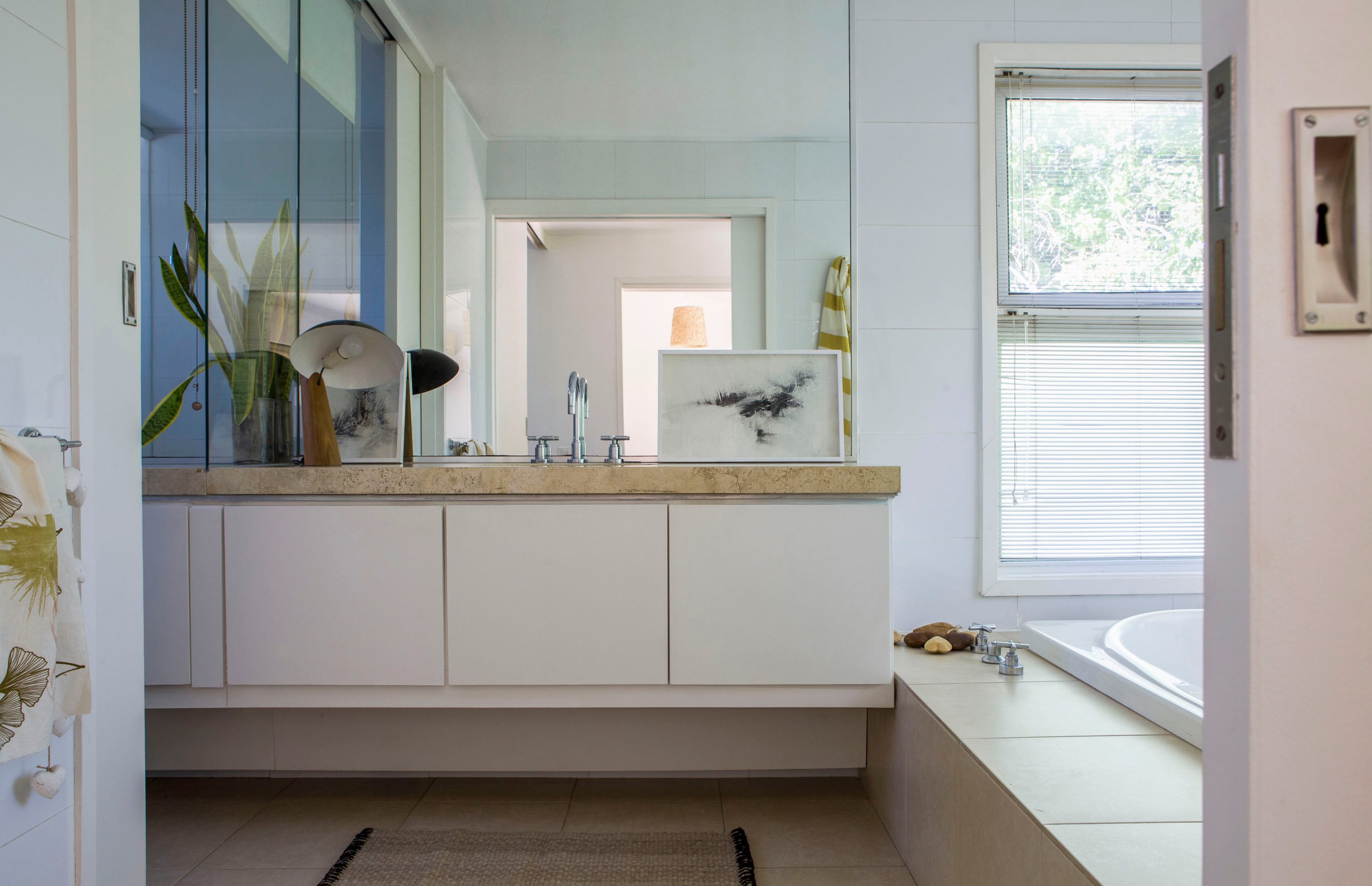 El baño mantiene el equipamiento de cuando se mudaron; paño (Plain Textiles) y obras (Lucila Sampayo) apoyadas sobre la mesada.