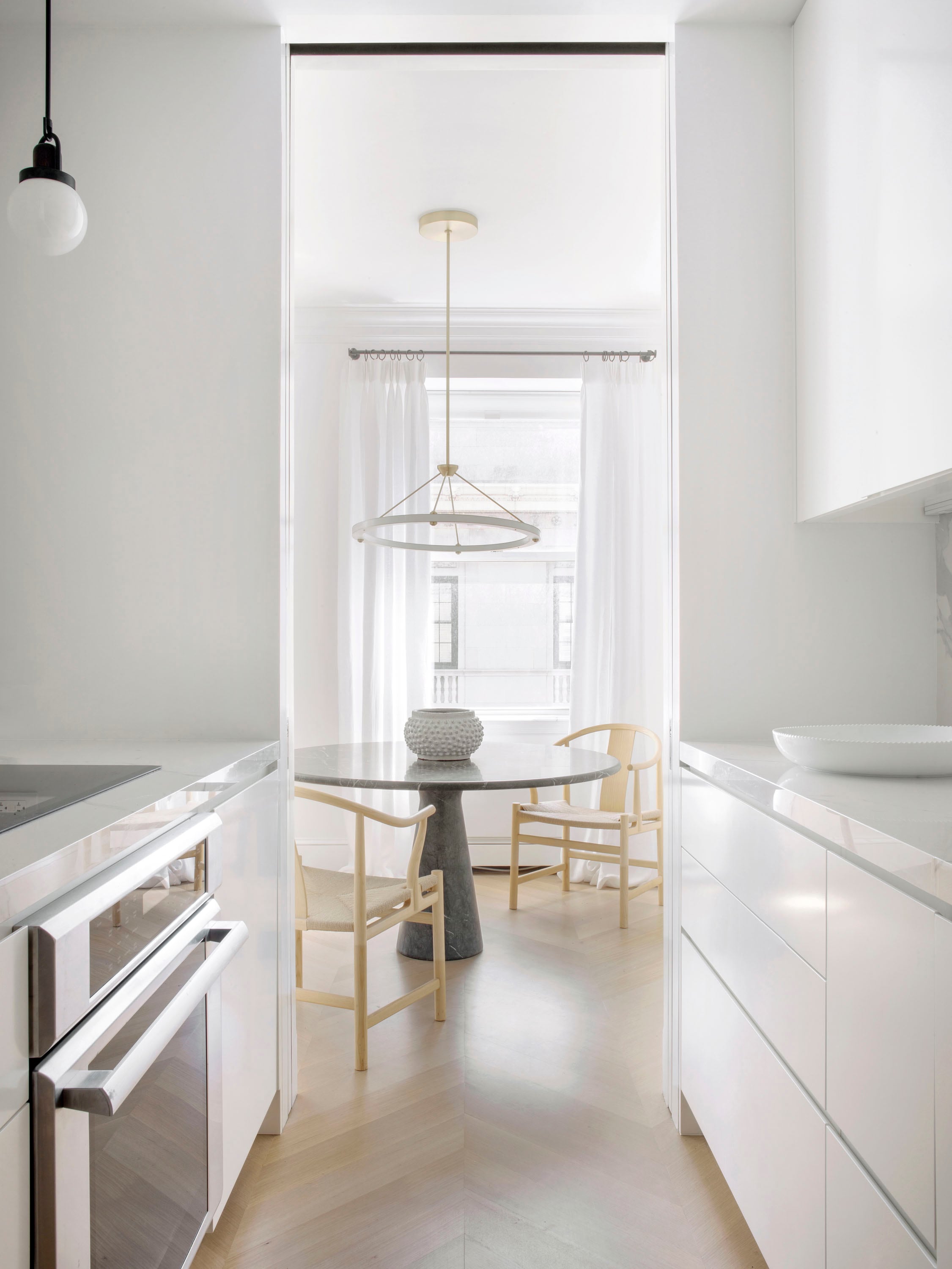 La cocina, de diseño despojado y paleta blanca, sigue la línea del comedor.