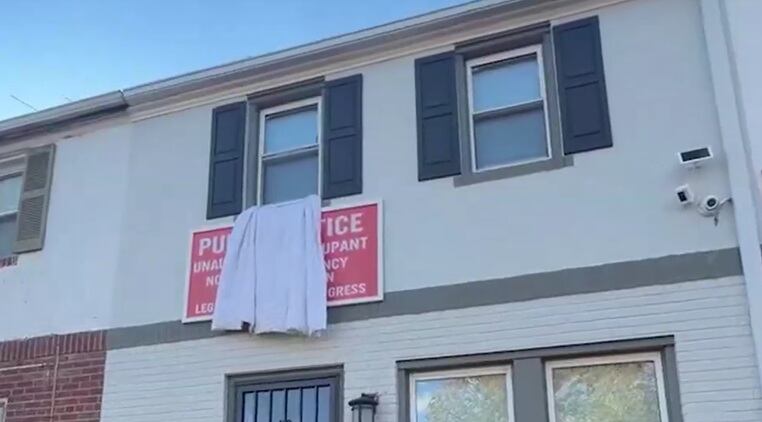 A través de un cartel, Douglas dio aviso a sus vecinos de que su casa fue tomada, pero la okupa lo tapó con una sabana blanca