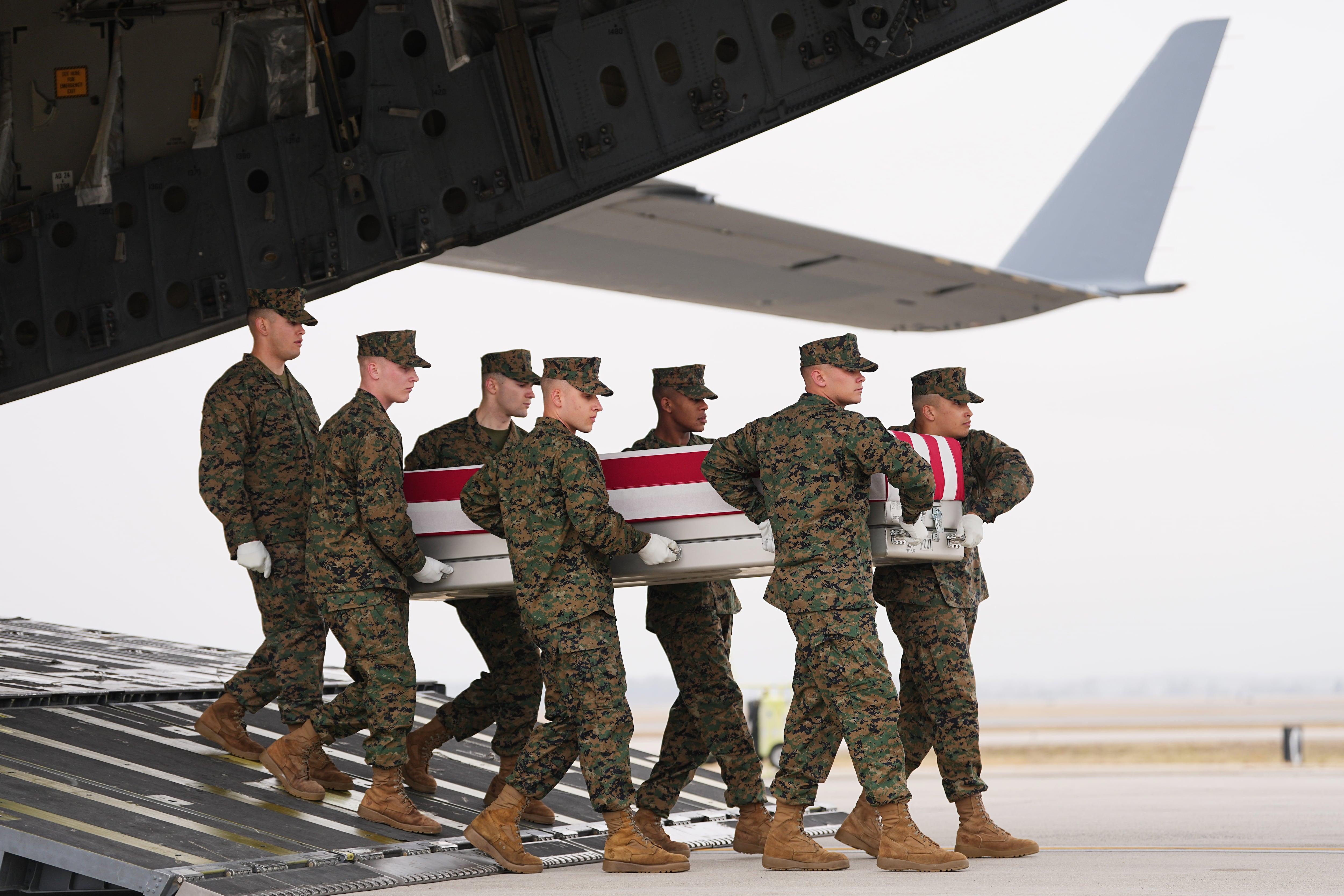Un equipo de transporte del Cuerpo de Marines traslada la caja de transferencia que contiene los restos del cabo primero del Cuerpo de Marines Kevin Melendez