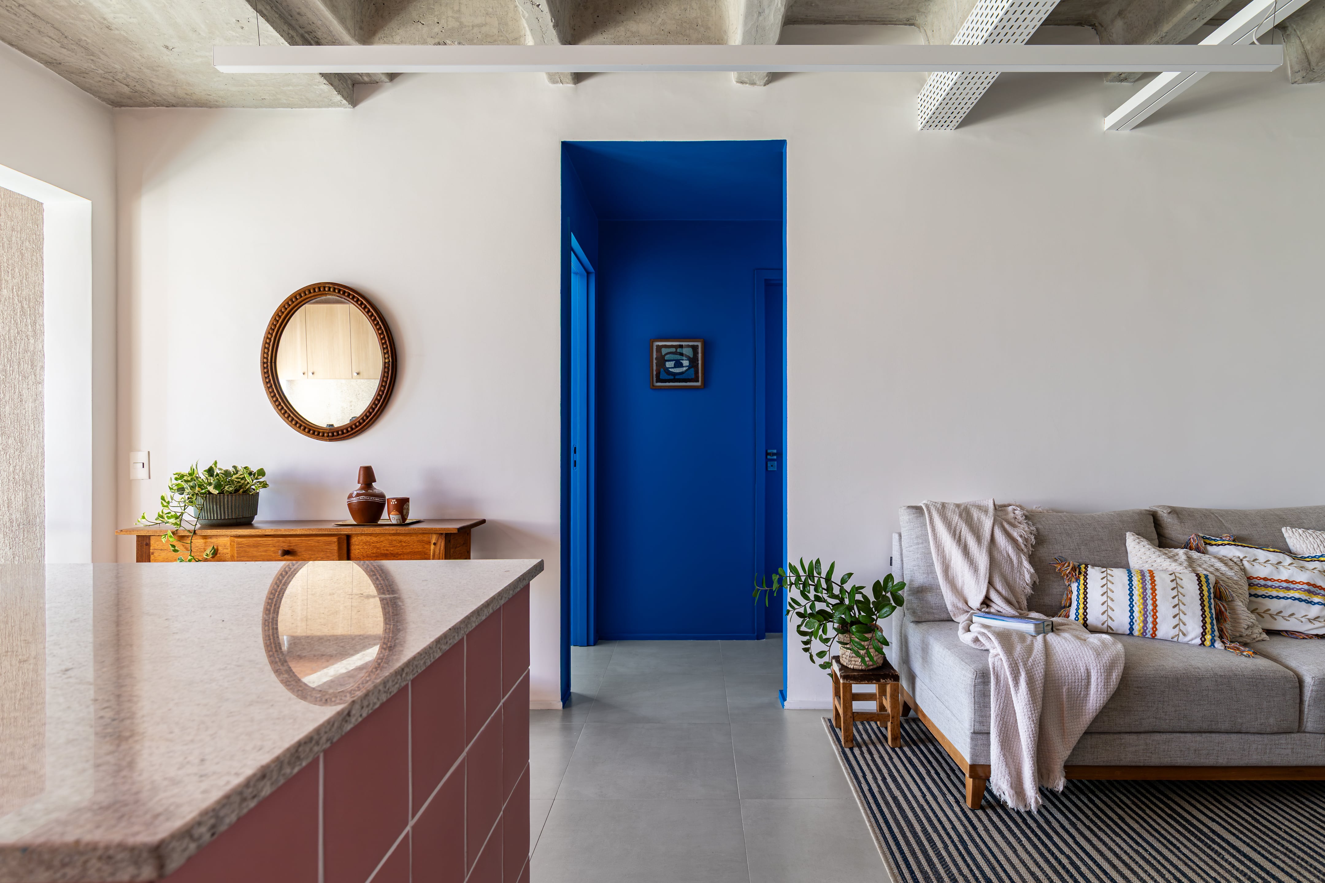 En contraste con el rosa de la cocina, el hall de acceso a los ambientes privados se tiñó de un azul profundo.