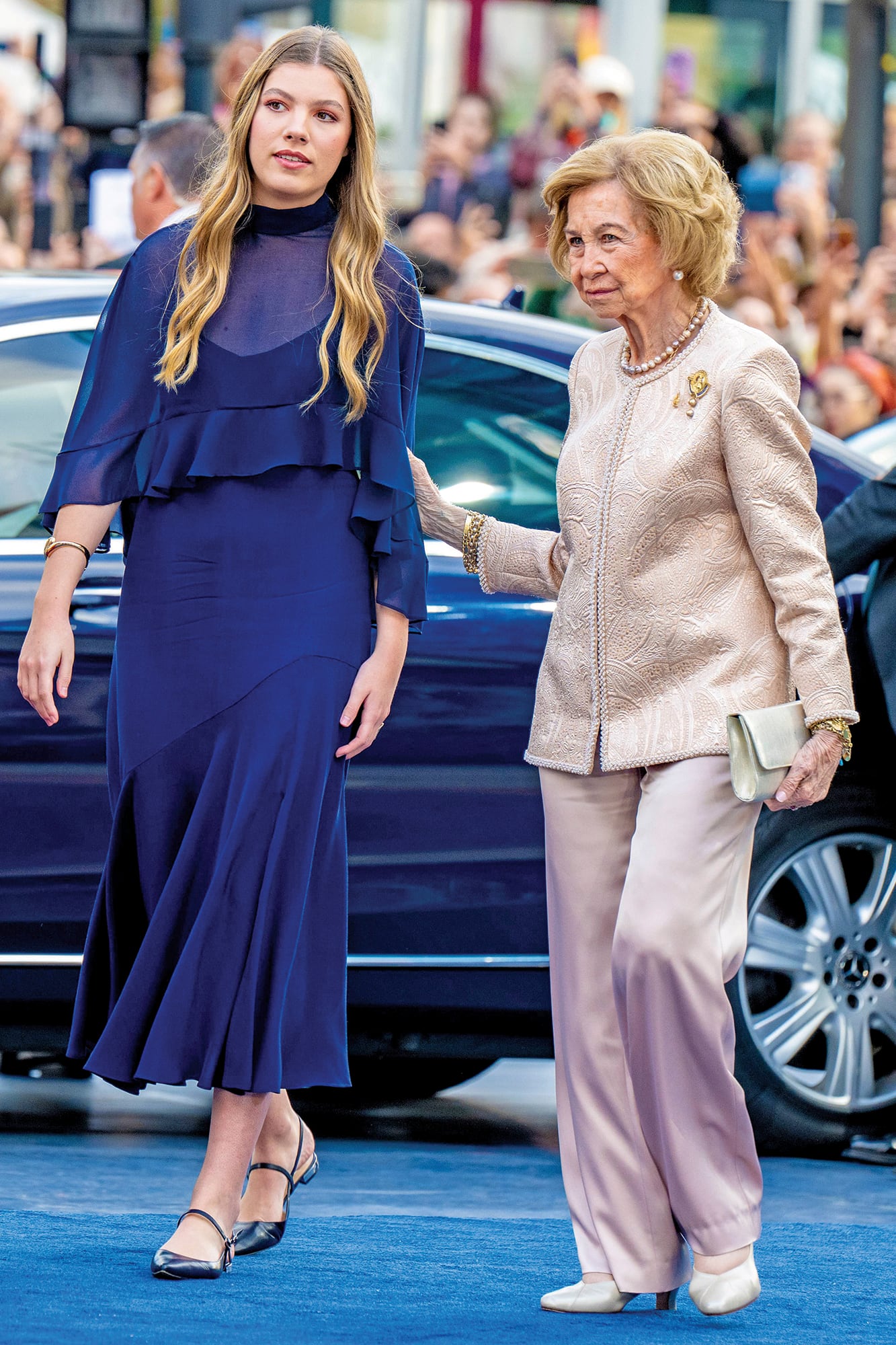 La infanta Sofía –con un vestido azul noche de Miphai, zapatos haciendo juego, un colgante en forma de la Cruz de la Victoria y el anillo de Karen Hallam de su madre–, junto a su abuela, la reina emérita Sofía (con traje sastre bicolor y un broche floral)