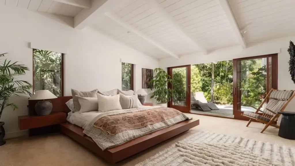 Suite principal con techo de madera a la vista, grandes superficies vidriadas y disposición estratégica para maximizar la luz natural y las vistas al parque