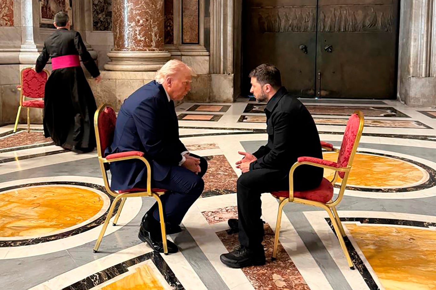En esta fotografía proporcionada por la Oficina de Prensa de la Presidencia ucraniana, el presidente Volodimir Zelensky y el mandatario estadounidense Donald Trump conversan durante su asistencia al funeral del papa Francisco en la Basílica de San Pedro, el 26 de abril de 2025, en Ciudad del Vaticano