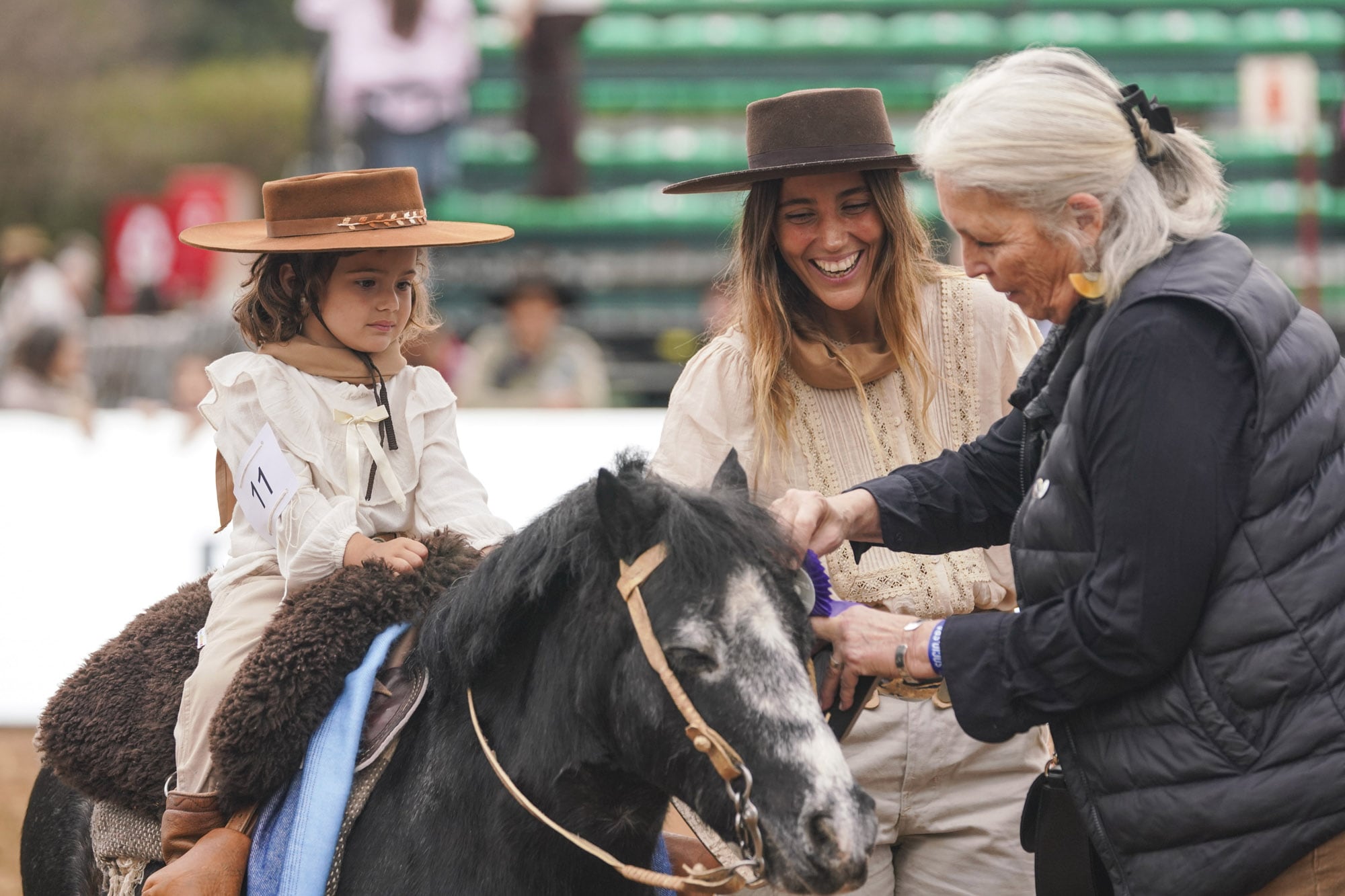 Marina Facht recibe en la pista a Cuña Arzuaga Pedascoll, de apenas dos años, acompañada por su mamá, Bahía Pedascoll