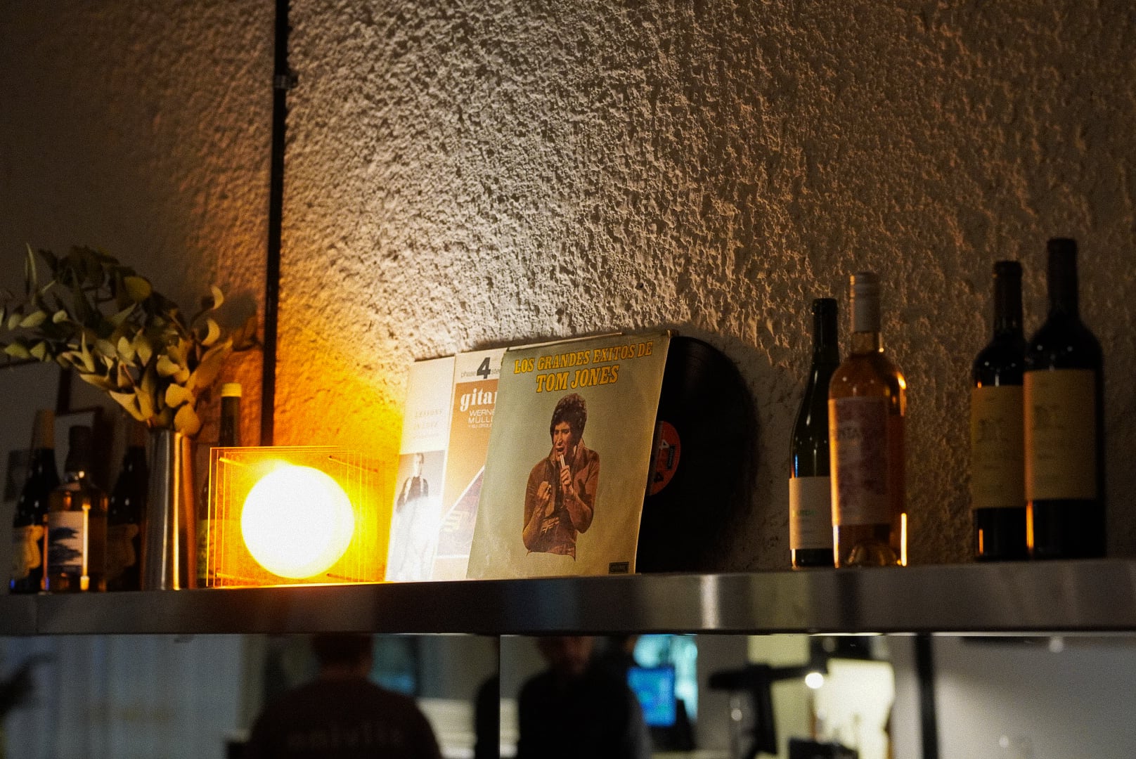 Vinilos y botellas de vino decoran los estantes