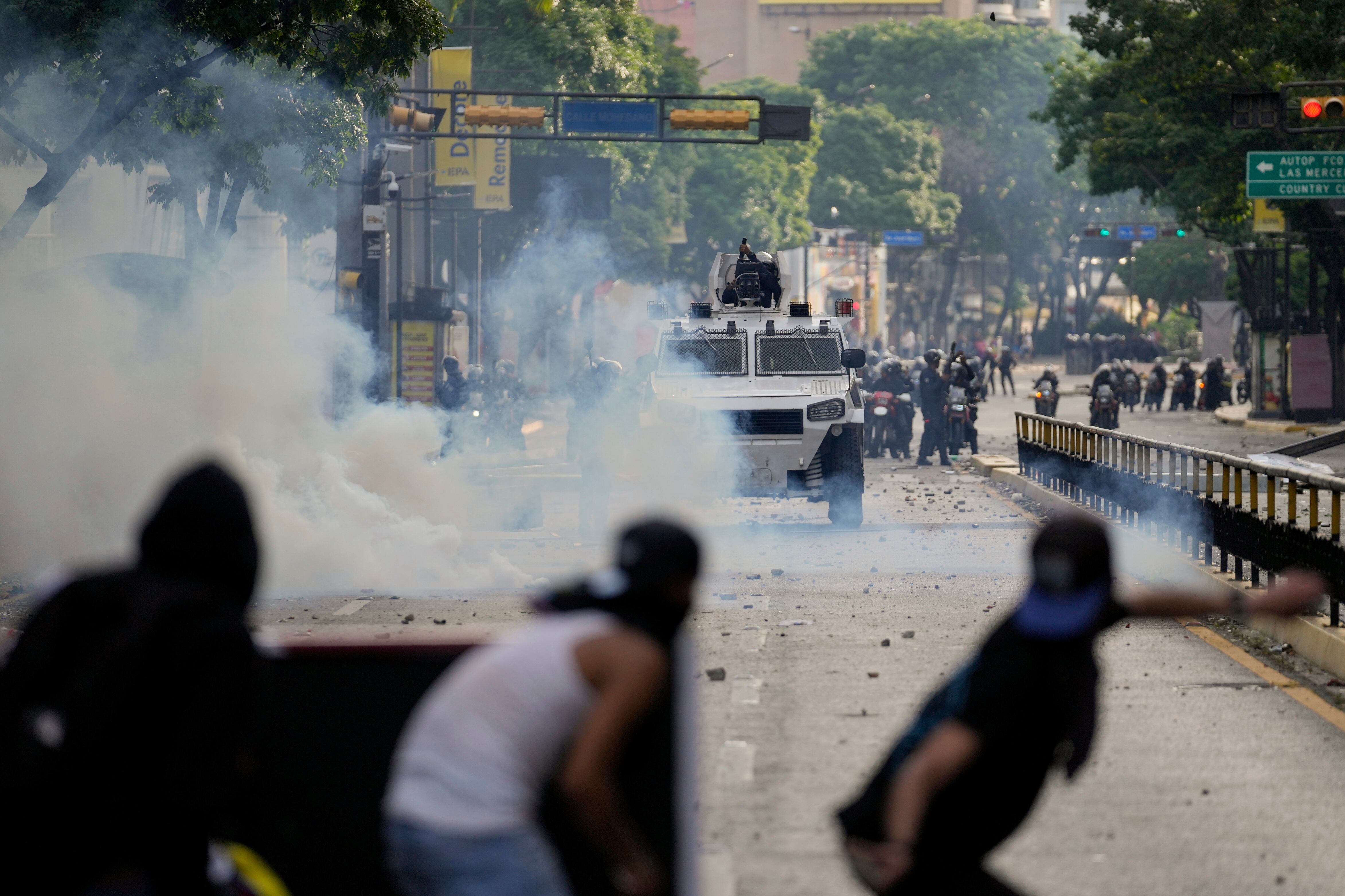 Manifestantes se enfrentan con la policía durante protestas por el fraude electoral de los comicios presidenciales