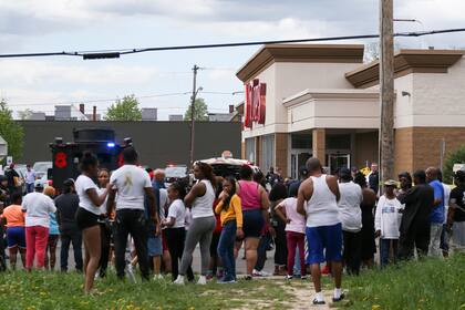 A crowd gathers as police investigate after a shooting at a supermarket on Saturday, May 14, 2022, in Buffalo, N.Y. Multiple people were shot  at the Tops Friendly Market.  Police have notified the public that the alleged shooter was in custody. (AP Photo/Joshua Bessex)