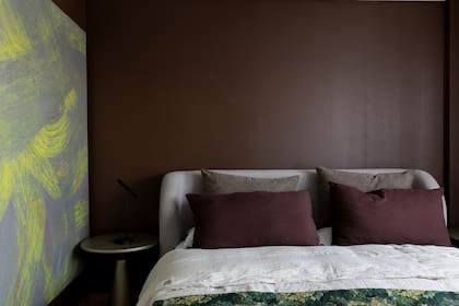 A diferencia de las áreas sociales, ambientadas con tonos neutros, el cuarto cobra protagonismo con un tono chocolate (D162-6).