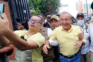 A fan takes a selfie picture with Colombian independent presidential candidate Rodolfo Hernandez (R) as he leaves the polling station after voting in Bucaramanga, Colombia, on May 29, 2022, during the presidential election. (Photo by Schneyder MENDOZA / AFP)