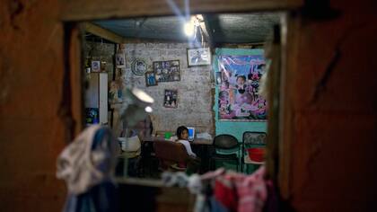Una chica mira desde su casa en la villa 31