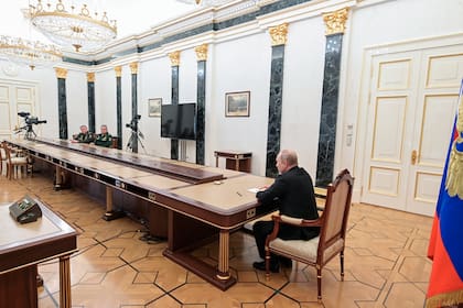 A gran distancia, Vladimir Putin (der.) habla con su ministro de Defensa Sergei Shoigu (segundo desde la izq.) y el jefe del Estado Mayor de las fuerzas armadas de Rusia y primer viceministro de Defensa, Valery Gerasimov, el domingo 27 de febrero de 2022