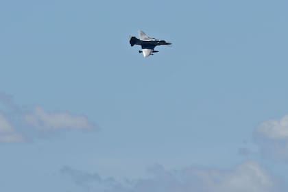 Un avión militar vuela sobre el Obelisco mientras los fanáticos de Argentina esperan que pase el autobús con los jugadores de Argentina para celebrar después de ganar el torneo de la Copa Mundial de Qatar 2022 en Buenos Aires el 20 de diciembre de 2022