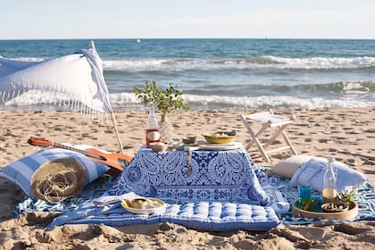 A orillas del mar, un almuerzo romántico. La canasta donde trajimos todo o una mesa baja cubierta con géneros livianos, mantienen la comida lejos de la arena. Conviene pensar un menú sin cubiertos y fácil de preparar. Estilismo: Sol van Dorssen