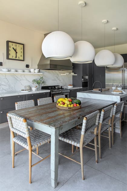 A partir del amoblamiento de base, Joanne seleccionó una mesa de fines del siglo XIX y sillas de cuero trenzado, juego que contrasta con las lámparas ‘Knit’ (Vibia).