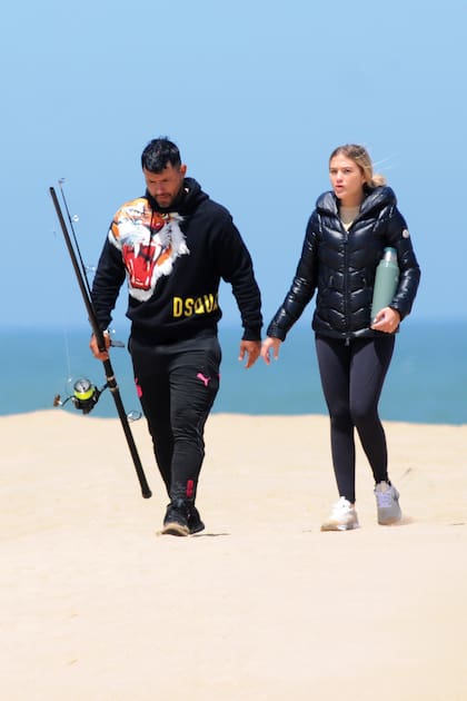 A pesar del día soleado, el viento soplaba fuerte y la pareja se abrigó para bajar a la playa.