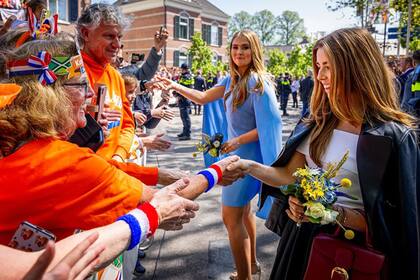 A su llegada, las princesas Amalia y Alexia saludan a quienes se acercaron para ver a la familia real de cerca.