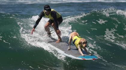 Un dueño surfea en tándem con su mascota
