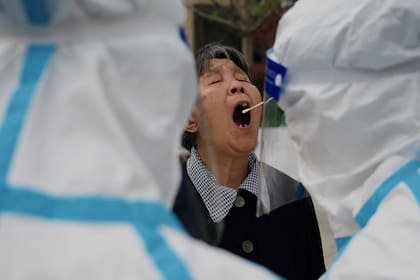 A un residente se le toma una muestra para analizar el coronavirus Covid-19 en un lugar de recogida de hisopos en Pekín el 25 de abril de 2022.