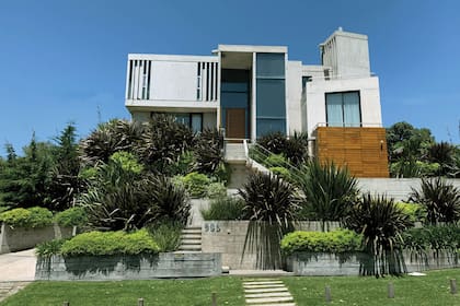 El jardín del frente escalonado está constituido por canteros largos de mampostería, que –junto con las contenciones de durmientes– van salvando el gran desnivel.