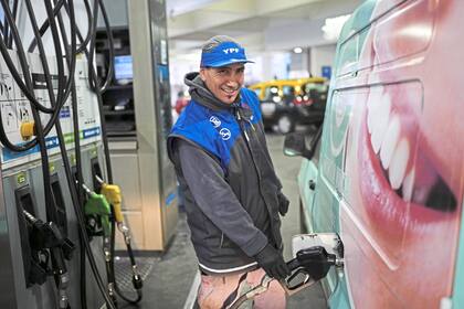 A worker fuels up a van at a YPF gas station in Buenos Aires, Argentina, Monday, July 14, 2025. YPF (AP Photo/Rodrigo Abd)