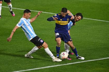 Aaron Molinas entre dos rivales de Argentinos Juniors, en la Bombonera
