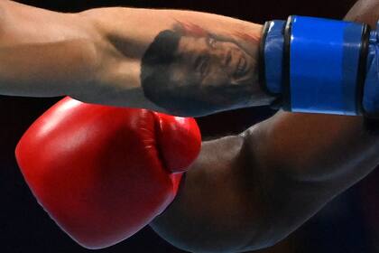 Aaron Solomon Prince de Trinidad y Tobago (rojo) y Andrej Csemez de Eslovaquia pelean durante su combate de boxeo preliminar de peso medio masculino (69-75 kg) durante los Juegos Olímpicos de Tokio 2020 en el Kokugikan Arena de Tokio el 26 de julio de 2021