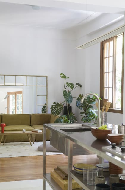 Abierta al living, la cocina tiene una isla de acero inoxidable fuera de lo convencional (Darío y Joaquina)