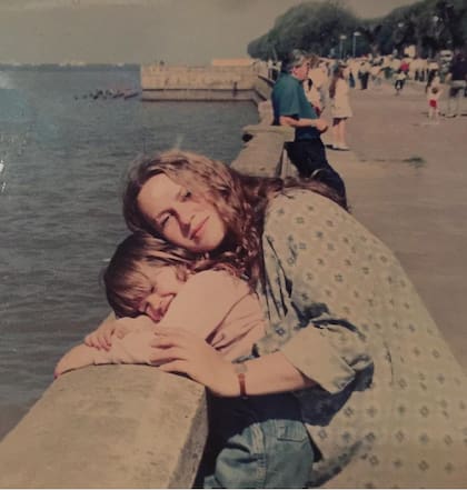 Abrazada junto a su madre, que se le parece mucho.