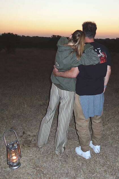 Abrazados, Carla y Diego disfrutan del maravilloso atardecer en la sabana africana.