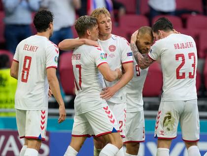 Abrazos entre los futbolistas de Dinamarca, una selección que por momentos pasó por arriba a Gales en el primer partido de los octavos de final de la Euro 2020.