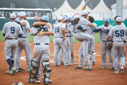 Abrazos y festejos de los jugadores, con familiares en la tribuna en el diamante de Villa María del Triunfo; otro día de gloria panamericana