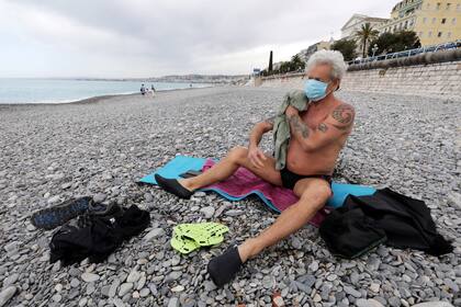 Un hombre se seca al salir del mar, en Niza