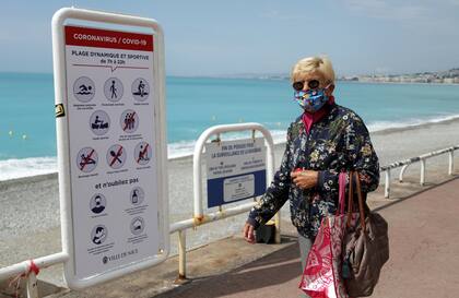 Una mujer aprovecha la salida de compras para recorrer la costanera en Niza, Francia