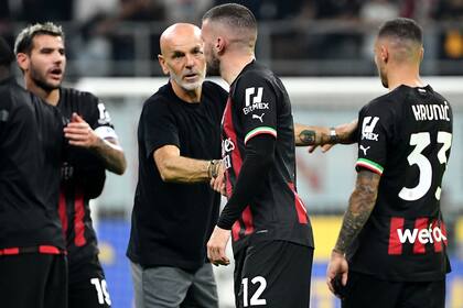 AC Milan's Italian coach Stefano Pioli (C) celebrates his team victory after the Italian Serie A football match between AC Milan and Juventus at the San Siro stadium in Milan on October 8, 2022. (Photo by Isabella BONOTTO / AFP)