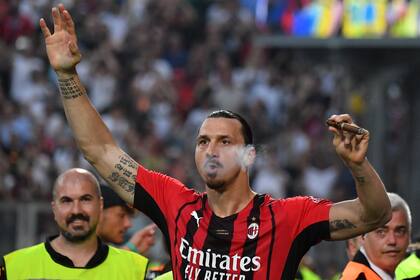 AC Milan's Swedish forward Zlatan Ibrahimovic smokes a cigar during the winner's trophy ceremony after AC Milan won the Italian Serie A football match between Sassuolo and AC Milan, securing the "Scudetto" championship on May 22, 2022 at the Mapei - Citta del Tricolore stadium in Sassuolo. (Photo by Tiziana FABI / AFP)