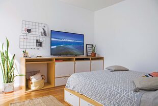Mueble de TV y cama en enchapado de guatambú lustrado con cajones de guardado en la base (todo del Estudio Alonso-Crippa). Acolchado y almohadones (Arredo). 