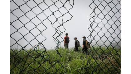 Activistas de HK URBEX a través de un agujero de un alambrado