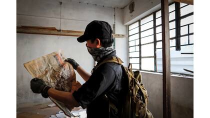 Un miembro de HK URBEX mira un diario de 1982 en el interior de un edificio residencial abandonado