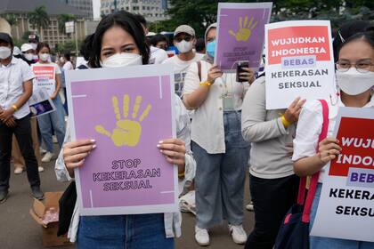 Activistas sostienen carteles con la frase "Paren la violencia sexual" y "Liberen Indonesia de la violencia sexual" durante una manifestación por el Día Internacional de la Mujer, en Yakarta, Indonesia, el 8 de marzo de 2022. (AP Foto/Tatan Syuflana)