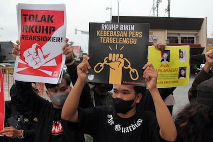 Activistas sostienen carteles durante una manifestación contra la nueva ley penal de Indonesia en Yogyakarta, Indonesia, martes 6 de diciembre de 2022.