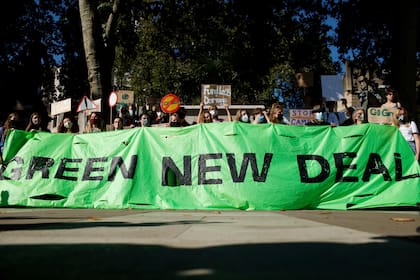 Activistas sostienen una pancarta que pide un "New Deal Verde" durante una manifestación de huelga climática, parte del movimiento global 'Fridays for Future liderado por la ambientalista adolescente sueca Greta Thunberg, en Parliament Square en Londres, el viernes 24 de septiembre 2021