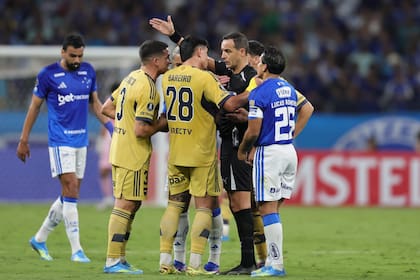 Adam Bareiro reclama su expulsión ante el uruguayo Esteban Ostojich: aunque la segunda infracción no era para amarilla, el paraguayo terminó pagando por la reiteración de faltas.