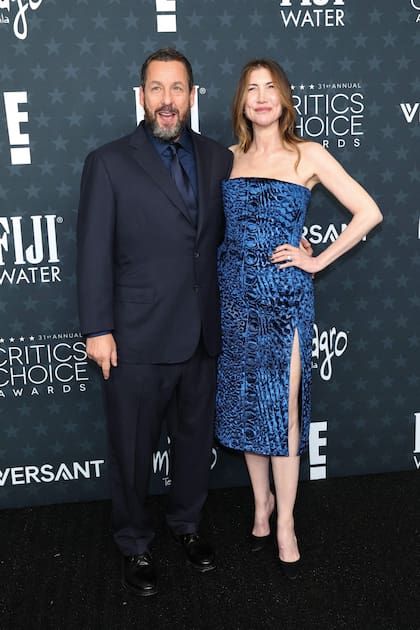 Adam Sandler, nominado al premio al mejor actor de reparto por su rol en el film de Netflix Jay Kelly, se mostró sonriente junto a su esposa, Jackie Sandler. El comediante optó por un look monocromático azul que combinó a la perfección con el vestido strapless de su mujer