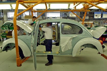 Foto de archivo de 2003, empleados de Volkswagen trabajan en la planta de ensamblaje del "Volkswagen Beetle" la última edición, en la planta de VW en Puebla a 105 km de la ciudad de México. Dejarán de producir este modelo de culto el 30 de julio